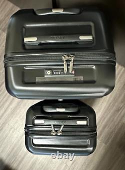 Ensemble de deux bagages rigides Delsey en couleurs noires dans une boîte ouverte